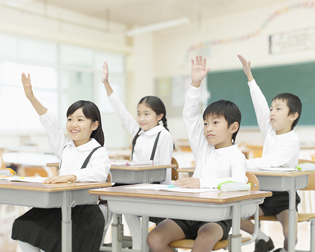 元気に挙手する子どもたちの画像